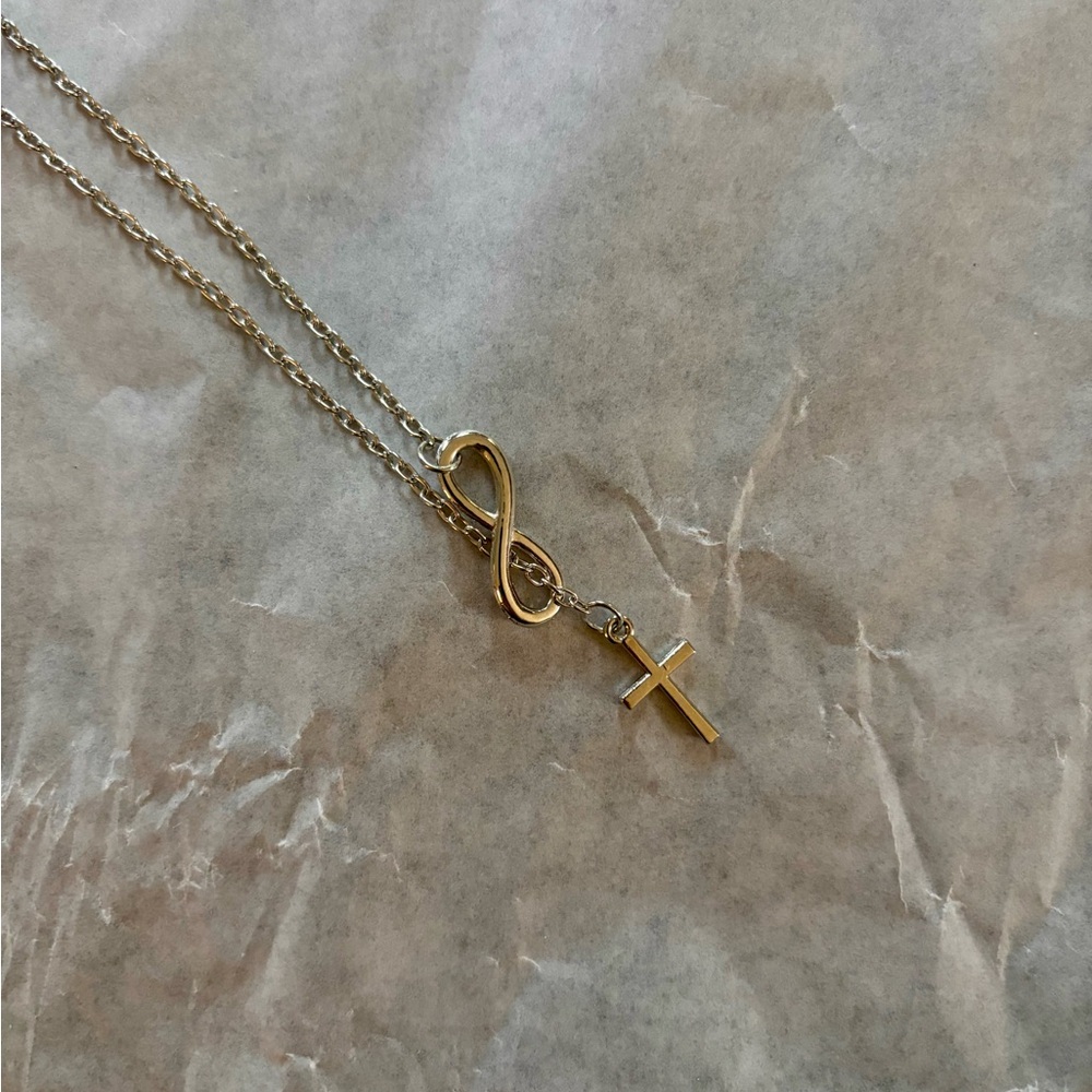 Silver tone necklace, infinity and cross pendants.